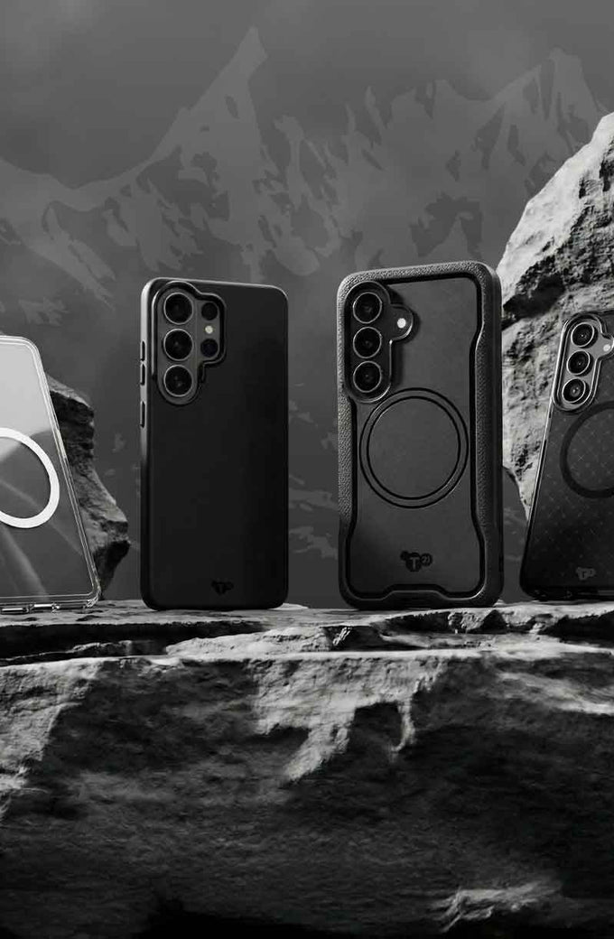 Four Samsung S26 devices in Tech21 cases sit on a rock in front of a mountain range